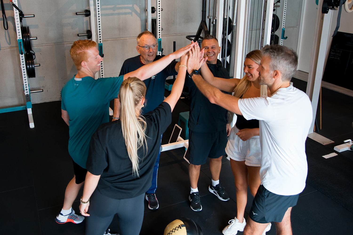 Collega's geven elkaar een high five na een bedrijfsuitje bij Whole-Fit Zandvoort
